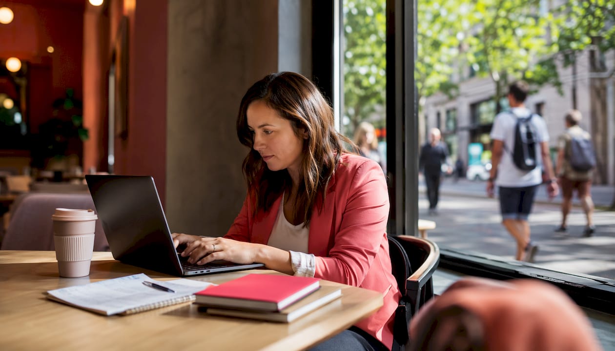 Marketer scheduling social media on laptop at coworking space