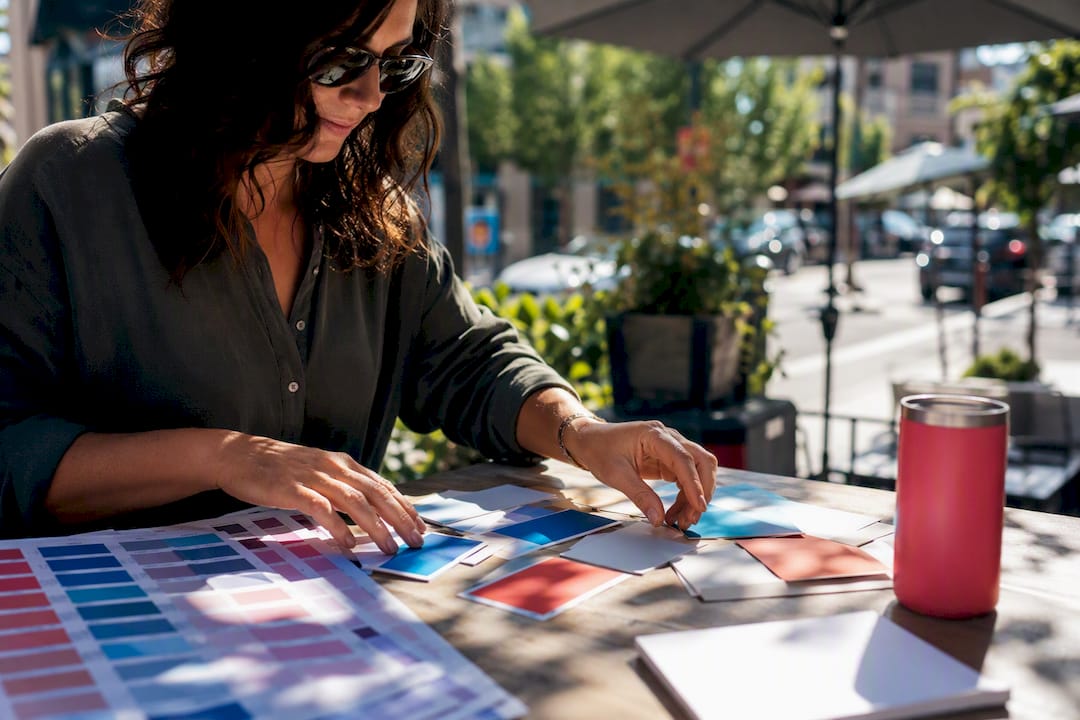 Hands arranging brand element samples on desk