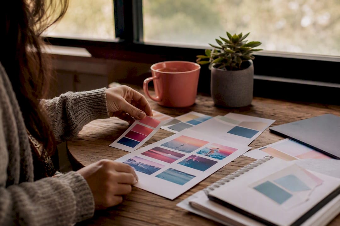 Hands arranging storyboards and color swatches on desk