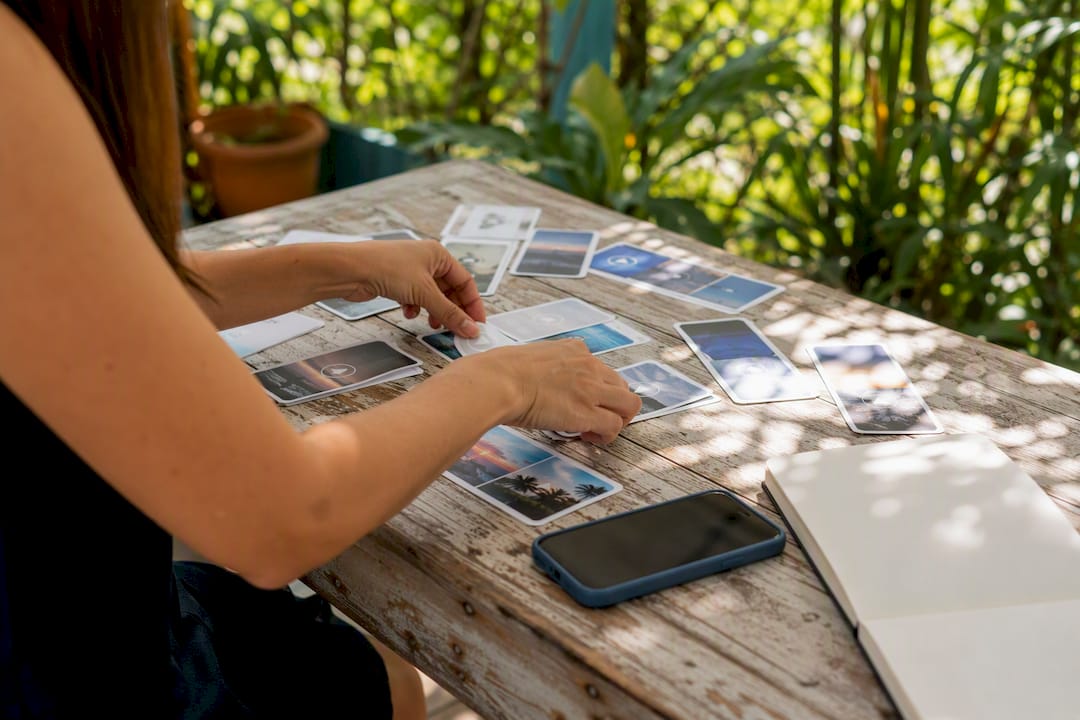Hands sorting social media content cards on table
