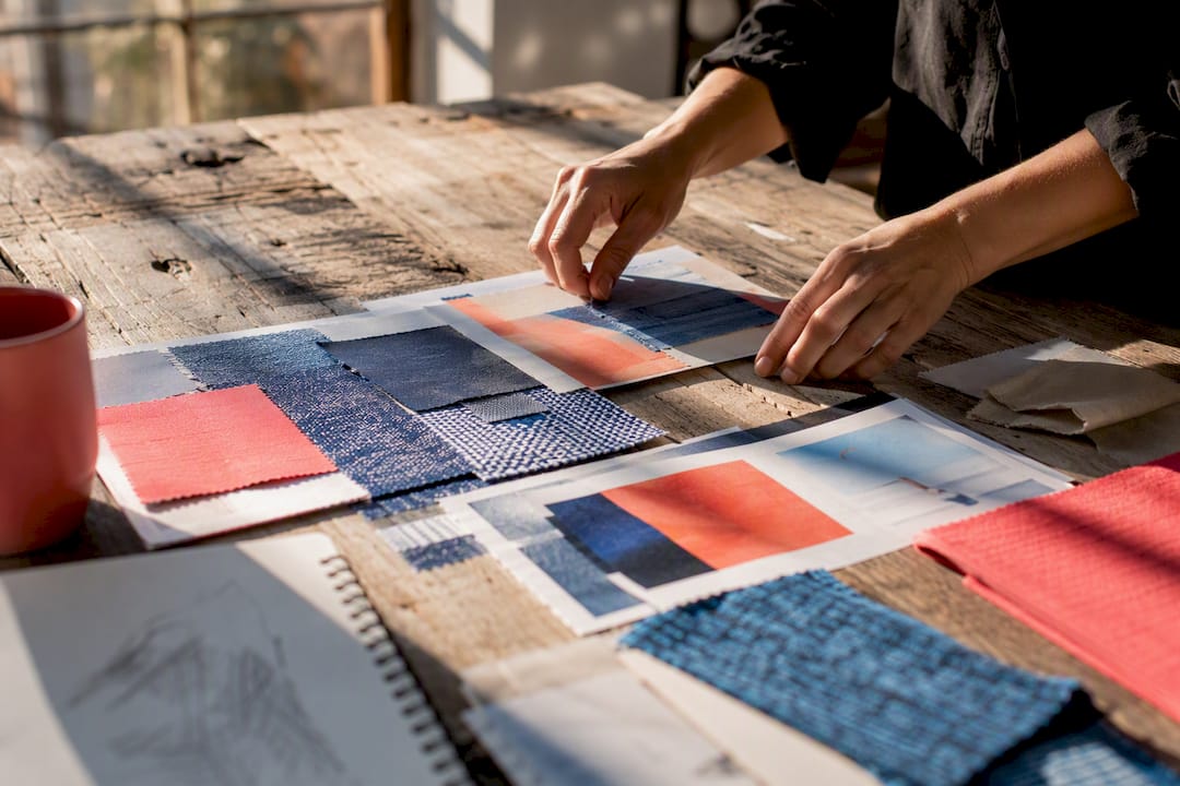 Hands arranging photos and swatches on table