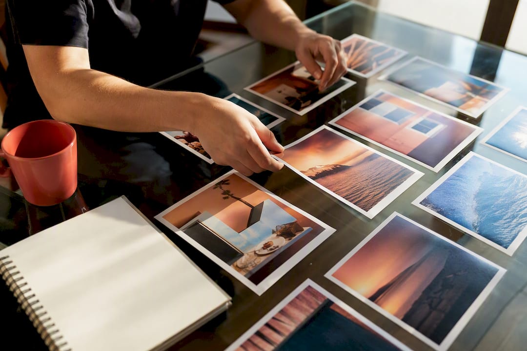 Hands arranging photos in sequence on desk